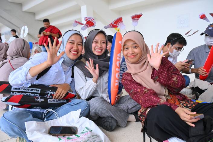 Tiga penonton berpose untuk foto saat mengantri masuk Istora GBK (Djarum Badminton)